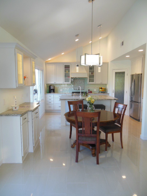 Mid-sized transitional l-shaped porcelain tile and white floor eat-in kitchen photo in San Diego with shaker cabinets, white cabinets, quartz countertops, green backsplash, subway tile backsplash, stainless steel appliances and an island