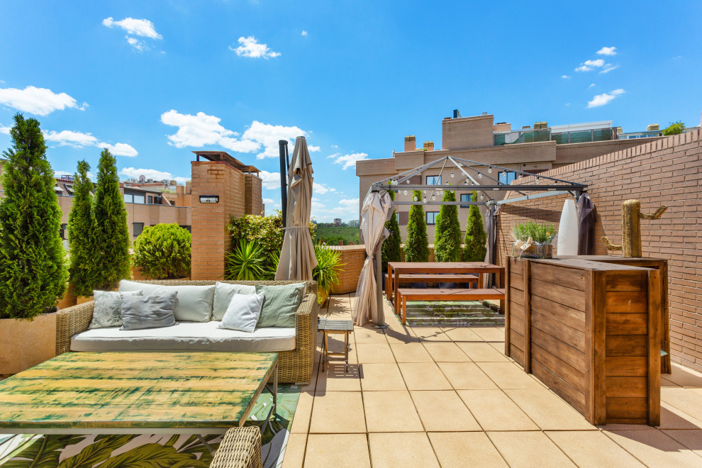 Photo of a large eclectic rooftop deck in Madrid with with privacy feature.