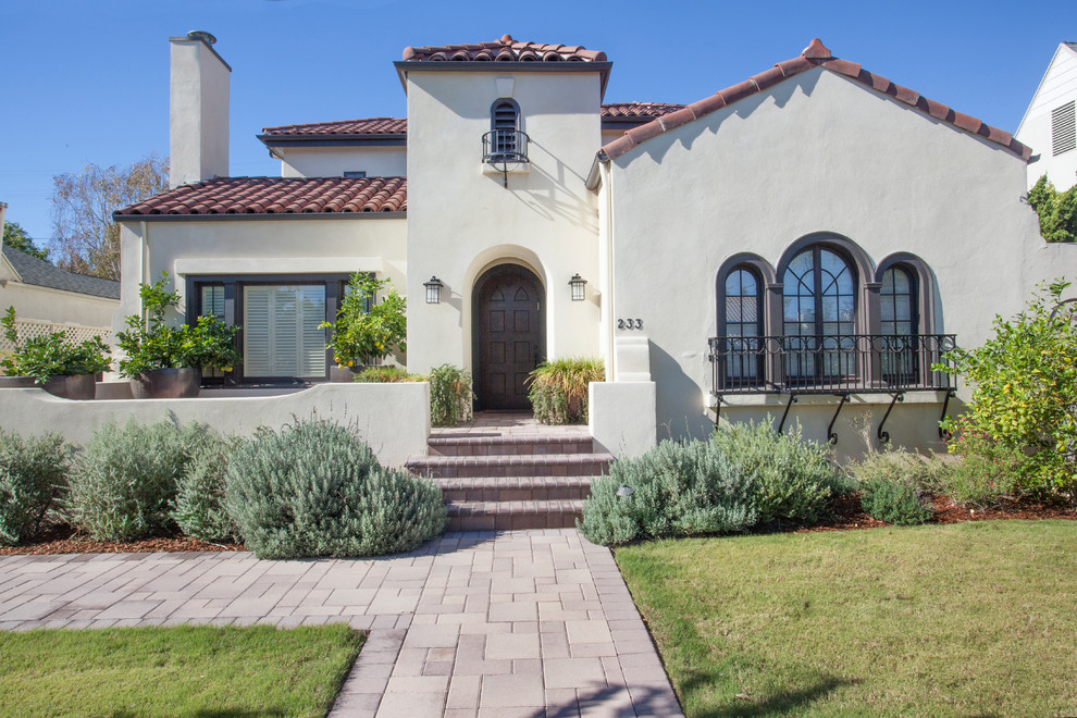 Inspiration for a large mediterranean two-storey stucco beige house exterior in Los Angeles with a gable roof and a tile roof.
