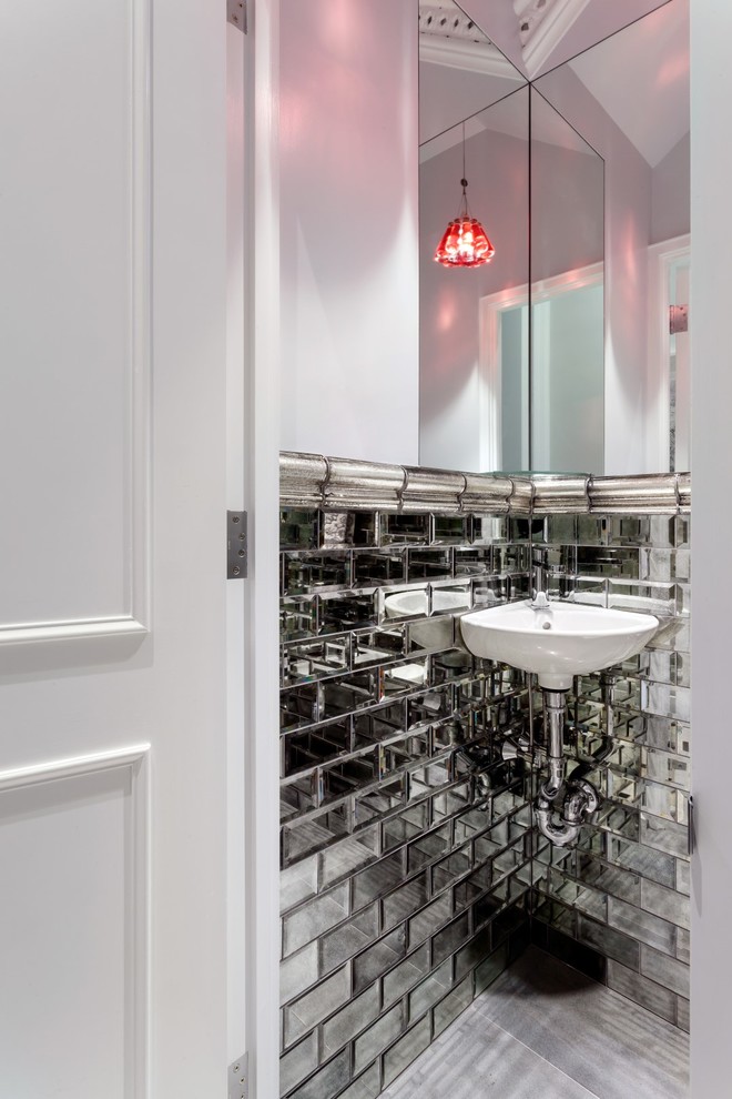 Photo of a small contemporary powder room in New York with mirror tile, white walls, porcelain floors and a wall-mount sink.