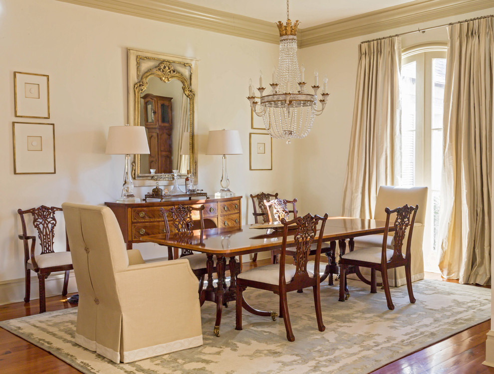 Traditional dining room in New Orleans with beige walls and dark hardwood floors.
