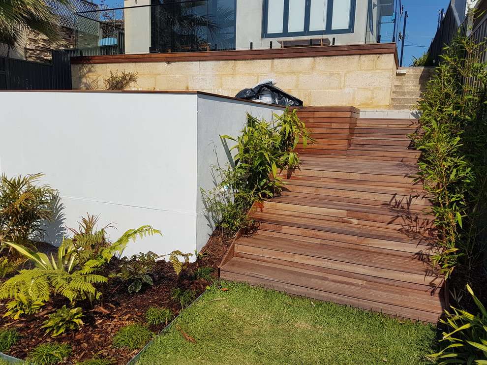 Design ideas for a modern sloped formal garden in Perth with a garden path and decking.