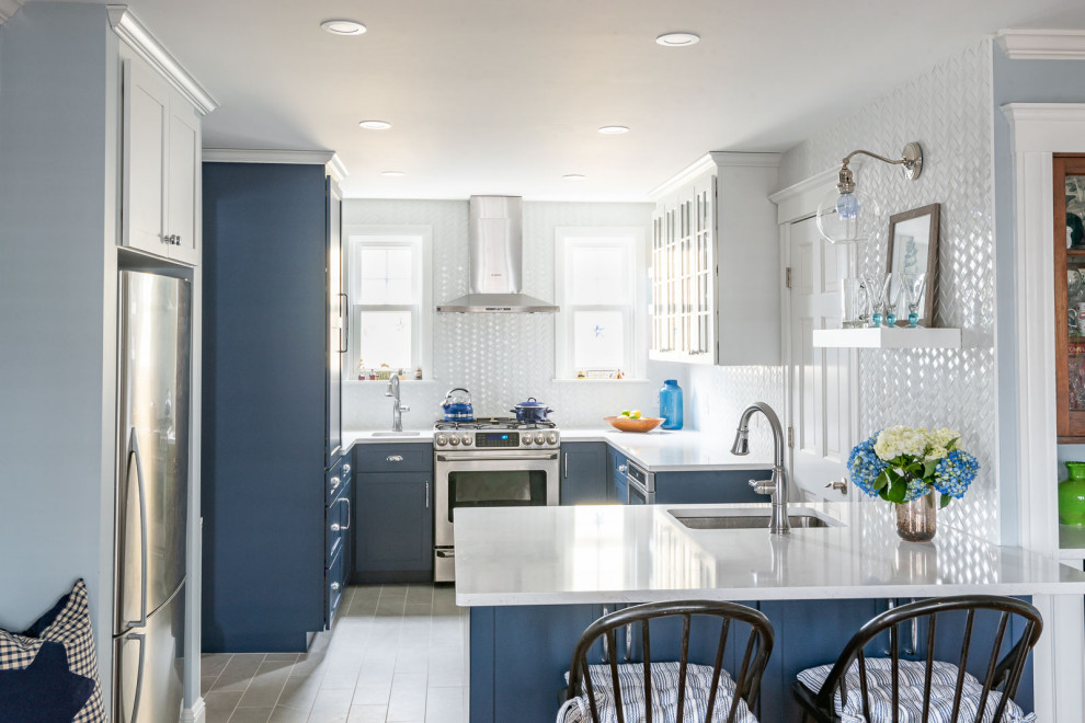 Mid-sized transitional u-shaped porcelain tile and gray floor eat-in kitchen photo in Boston with an undermount sink, shaker cabinets, blue cabinets, quartz countertops, white backsplash, subway tile backsplash, stainless steel appliances, a peninsula and white countertops