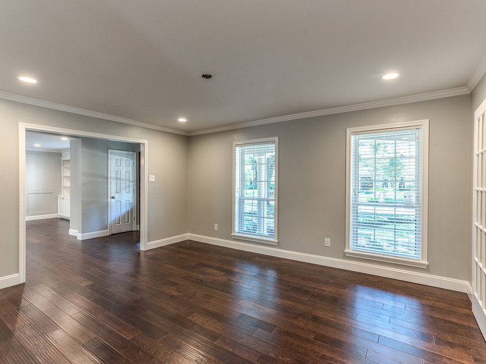 This is an example of a large traditional dining room in Houston with grey walls, dark hardwood floors and no fireplace.