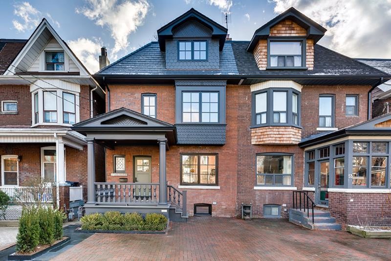 Design ideas for a large traditional three-storey brick red exterior in Toronto with a hip roof.