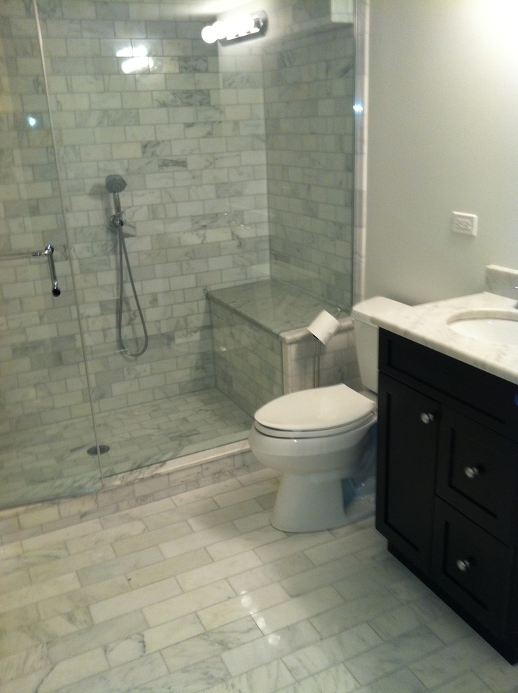 Mid-sized traditional 3/4 bathroom in Chicago with shaker cabinets, black cabinets, an alcove shower, a two-piece toilet, black and white tile, porcelain tile, white walls, marble floors, an undermount sink, marble benchtops, multi-coloured floor and a hinged shower door.