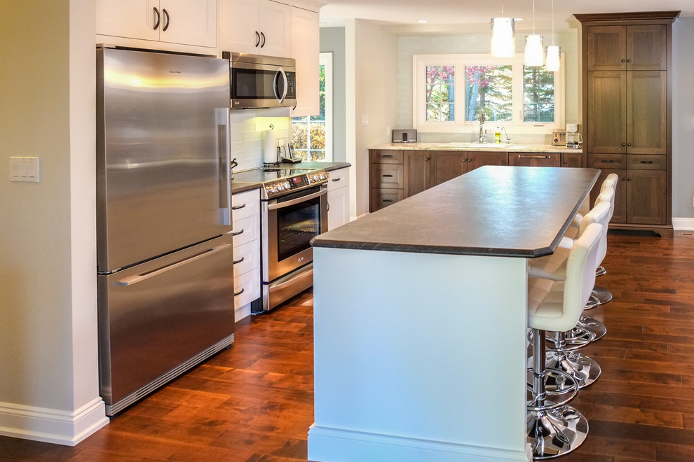 Mid-sized transitional medium tone wood floor eat-in kitchen photo in Calgary with a drop-in sink, recessed-panel cabinets, white cabinets, laminate countertops, blue backsplash, glass tile backsplash, stainless steel appliances and an island