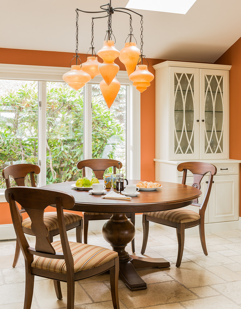 Inspiration for a traditional kitchen/dining combo in Boston with orange walls, no fireplace and travertine floors.