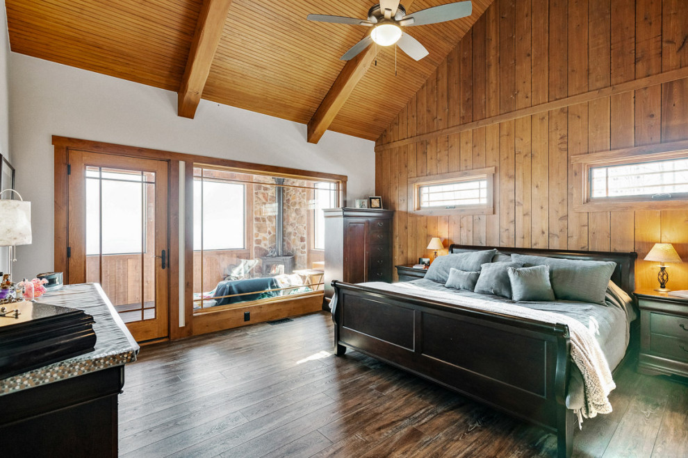 Ejemplo de dormitorio principal y abovedado rústico grande con suelo vinílico y madera