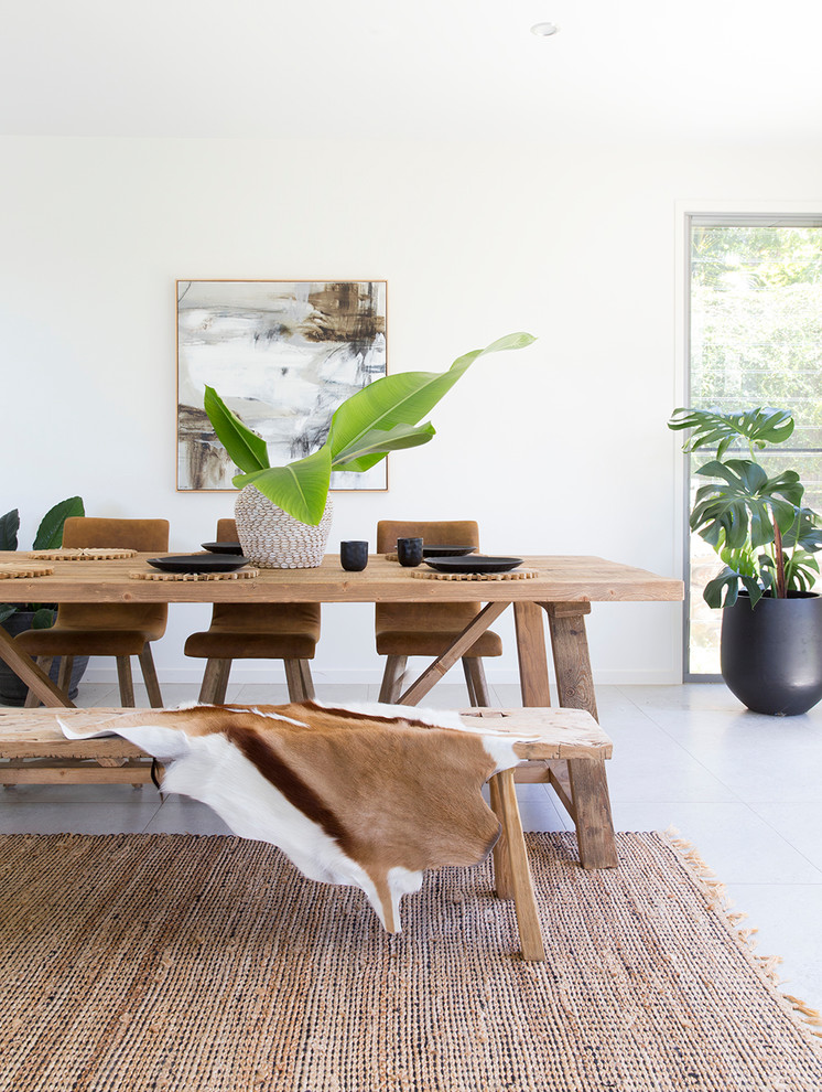 This is an example of a country open plan dining in Sunshine Coast with white walls and grey floor.
