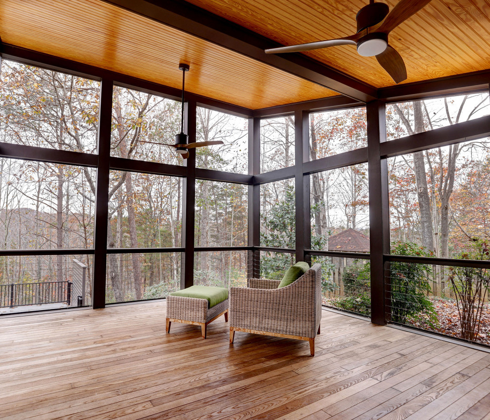 Inspiration pour un porche d'entrée de maison arrière minimaliste avec une moustiquaire, une extension de toiture et un garde-corps en métal.