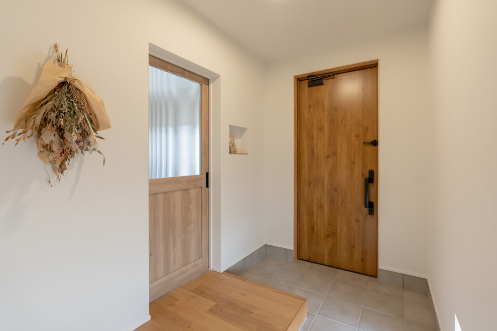 Idée de décoration pour une entrée minimaliste avec un couloir, un mur blanc, une porte simple, une porte en bois brun, un plafond en papier peint et du papier peint.