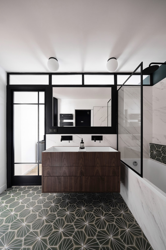 Inspiration for a mid-sized contemporary master bathroom in Paris with beaded inset cabinets, dark wood cabinets, an undermount tub, a two-piece toilet, black and white tile, marble, green walls, cement tiles, a trough sink, solid surface benchtops, green floor, white benchtops, a double vanity and a floating vanity.