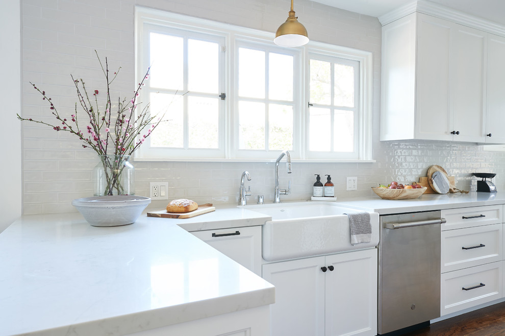 Inspiration for a mid-sized beach style galley eat-in kitchen in San Diego with an undermount sink, shaker cabinets, white cabinets, quartz benchtops, grey splashback, ceramic splashback, stainless steel appliances, medium hardwood floors, with island, brown floor and white benchtop.
