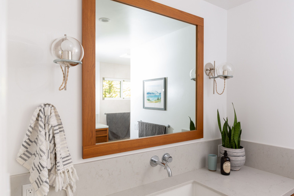 Large transitional master gray tile and ceramic tile ceramic tile and gray floor freestanding bathtub photo with furniture-like cabinets, brown cabinets, a two-piece toilet, white walls, a drop-in sink, quartz countertops and gray countertops