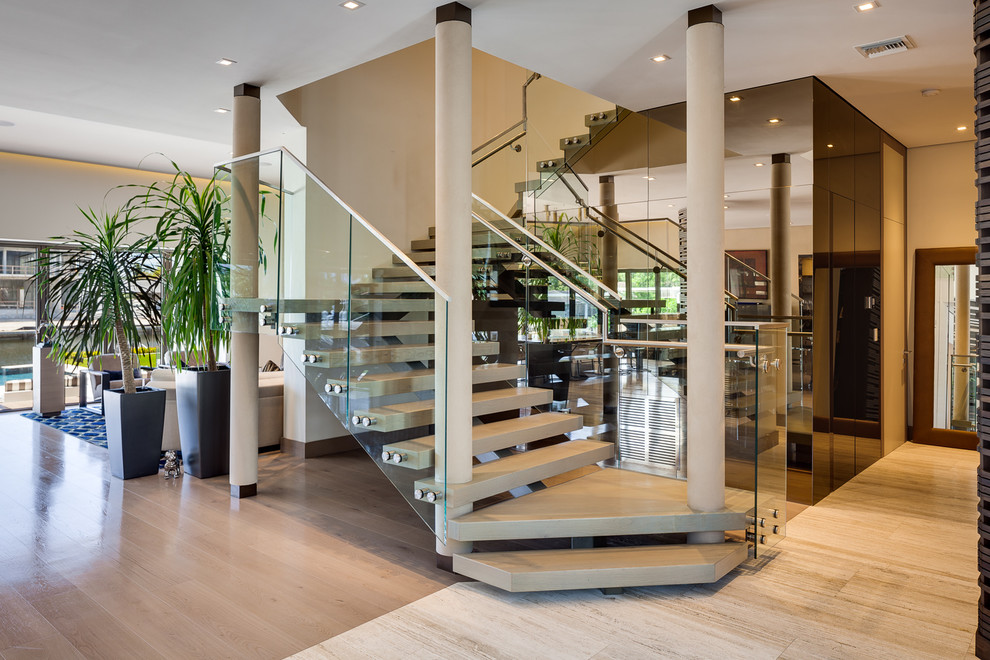 Contemporary floating staircase in Miami with open risers and glass railing.