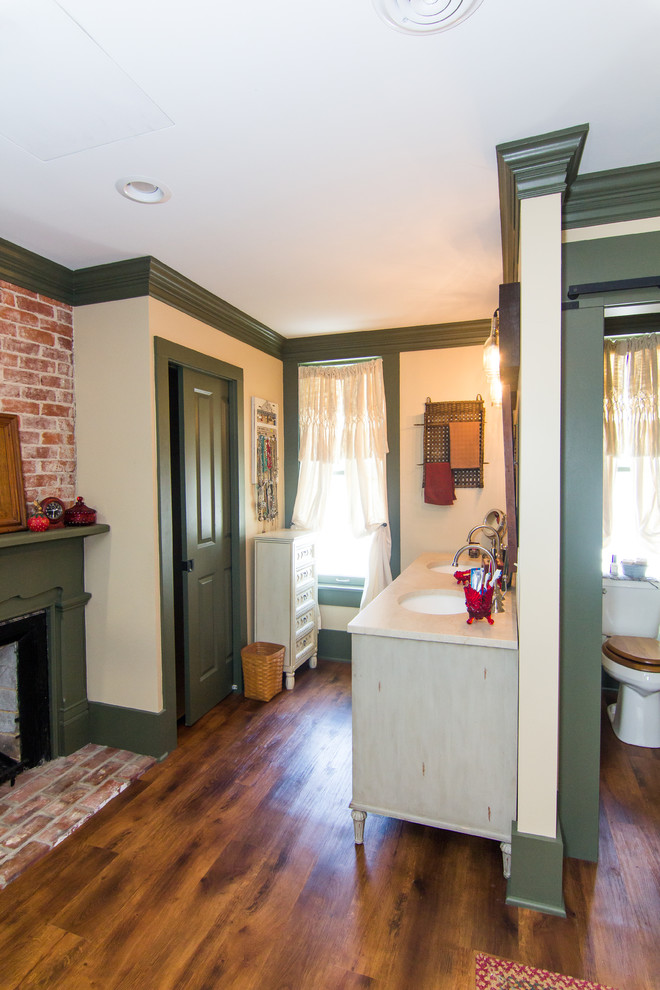 Inspiration for a large rustic master medium tone wood floor freestanding bathtub remodel with furniture-like cabinets, beige cabinets, a two-piece toilet, beige walls, an undermount sink, solid surface countertops and a hinged shower door