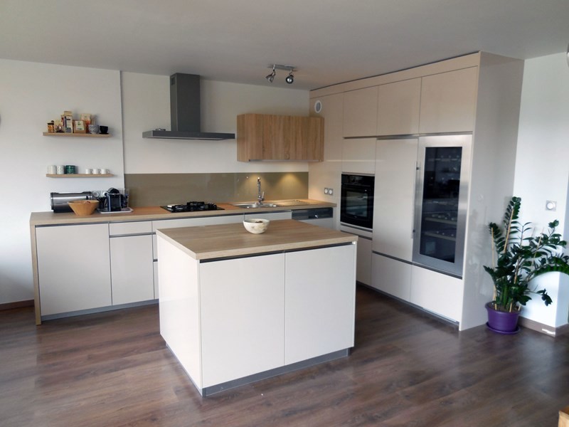 Photo of a mid-sized contemporary l-shaped open plan kitchen in Paris with an undermount sink, flat-panel cabinets, white cabinets, laminate benchtops, beige splashback, glass tile splashback, stainless steel appliances, dark hardwood floors, with island, brown floor and beige benchtop.