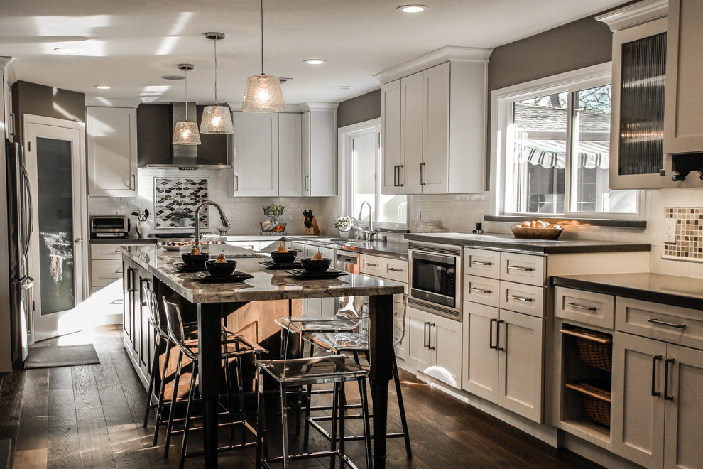 Design ideas for a large traditional u-shaped open plan kitchen in San Francisco with an undermount sink, shaker cabinets, white cabinets, granite benchtops, beige splashback, mosaic tile splashback, stainless steel appliances, with island and dark hardwood floors.