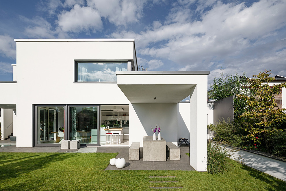 Inspiration for a large modern two-storey white exterior in Bonn with a flat roof.