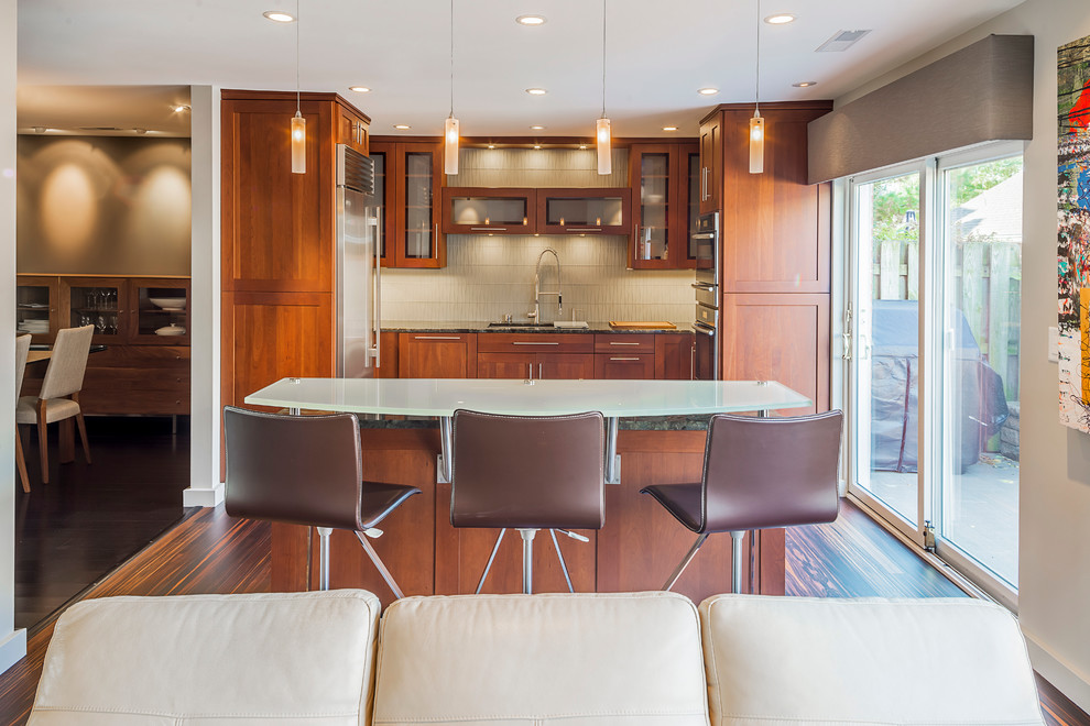 Inspiration for a mid-sized transitional galley bamboo floor eat-in kitchen remodel in Chicago with an undermount sink, recessed-panel cabinets, dark wood cabinets, quartz countertops, beige backsplash, glass tile backsplash, stainless steel appliances and an island