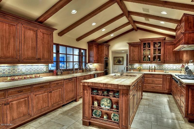 Example of a large transitional u-shaped ceramic tile kitchen design in Phoenix with a drop-in sink, raised-panel cabinets, medium tone wood cabinets, solid surface countertops, multicolored backsplash, mosaic tile backsplash, stainless steel appliances and an island