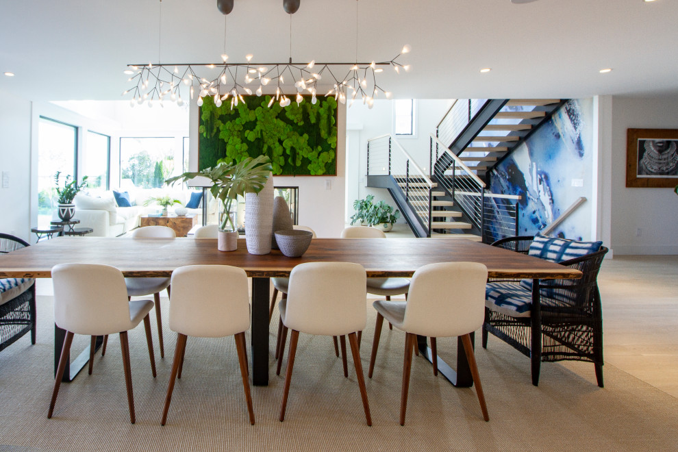 Photo of a beach style open plan dining in New York with white walls, light hardwood floors and beige floor.