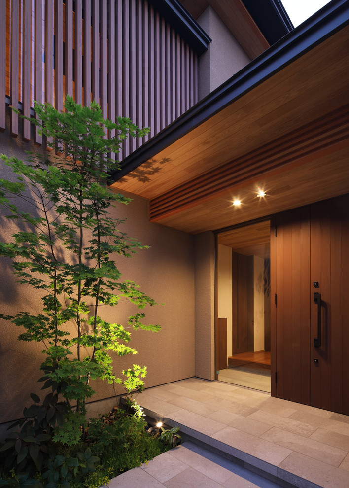 Cette image montre une grande porte d'entrée asiatique avec un mur beige, un sol en carrelage de porcelaine, une porte simple, une porte marron, un sol gris et un plafond en lambris de bois.