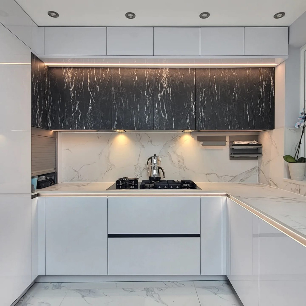 Inspiration for a mid-sized contemporary u-shaped eat-in kitchen in London with a drop-in sink, flat-panel cabinets, white cabinets, solid surface benchtops, white splashback, porcelain splashback, black appliances, porcelain floors, with island, white floor, white benchtop and vaulted.