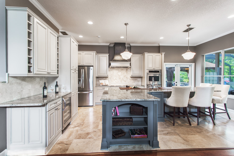 This is an example of a mid-sized traditional l-shaped eat-in kitchen in Jacksonville with raised-panel cabinets, stainless steel appliances, with island, a farmhouse sink, white cabinets, granite benchtops and beige splashback.