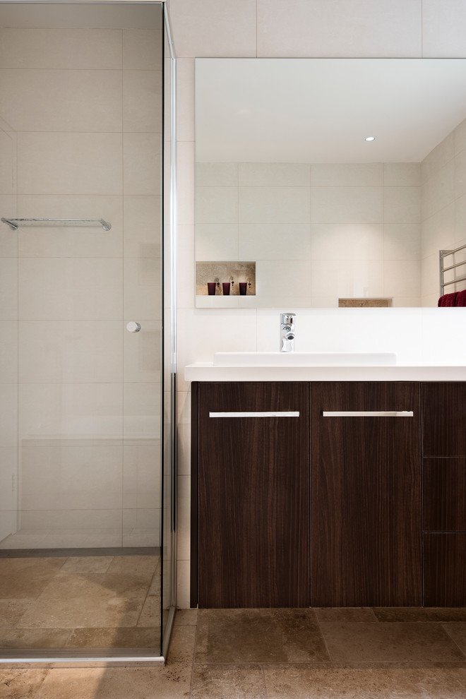 Inspiration for a mid-sized contemporary master bathroom in Sydney with a drop-in sink, furniture-like cabinets, medium wood cabinets, engineered quartz benchtops, a curbless shower, a one-piece toilet, beige tile, white walls, ceramic floors, ceramic tile, brown floor and a hinged shower door.