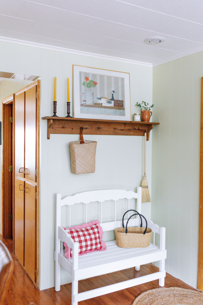 Mudroom - small cottage medium tone wood floor and wall paneling mudroom idea in Other with green walls