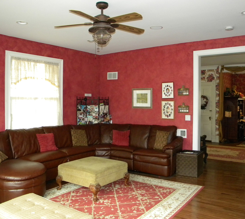 This is an example of a mid-sized traditional formal open concept living room in Chicago with red walls, medium hardwood floors, a standard fireplace, a wall-mounted tv, brown floor, a wood fireplace surround, wallpaper and wallpaper.