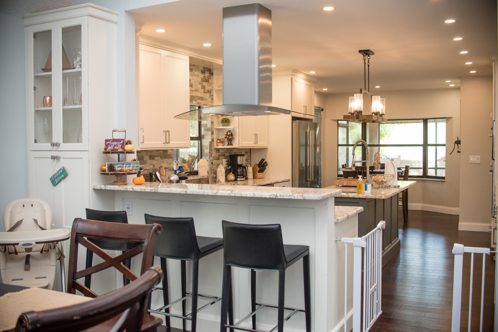 Example of a mid-sized transitional brown floor eat-in kitchen design in Boston with flat-panel cabinets, white cabinets, an island, an undermount sink, granite countertops, multicolored backsplash, stainless steel appliances and white countertops