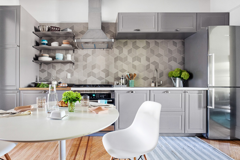 Inspiration for a mid-sized transitional single-wall eat-in kitchen in New York with grey cabinets, grey splashback, no island and medium hardwood floors.