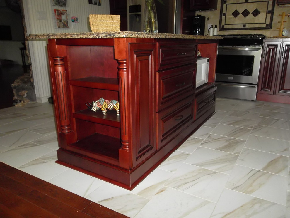 Mid-sized transitional l-shaped ceramic tile kitchen photo with a drop-in sink, dark wood cabinets, granite countertops, stone tile backsplash, stainless steel appliances, an island and raised-panel cabinets