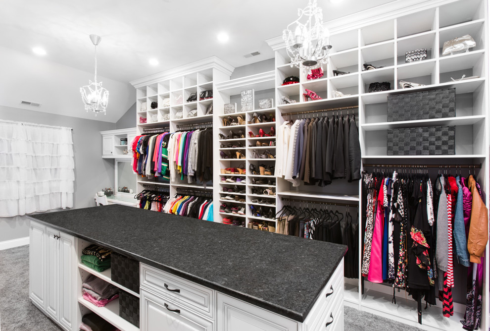Example of a large classic carpeted walk-in closet design in Chicago with raised-panel cabinets and white cabinets