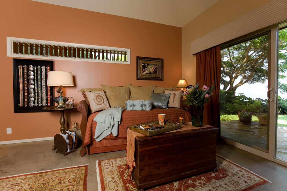This is an example of a large tropical guest bedroom in Hawaii with orange walls, concrete floors and brown floor.