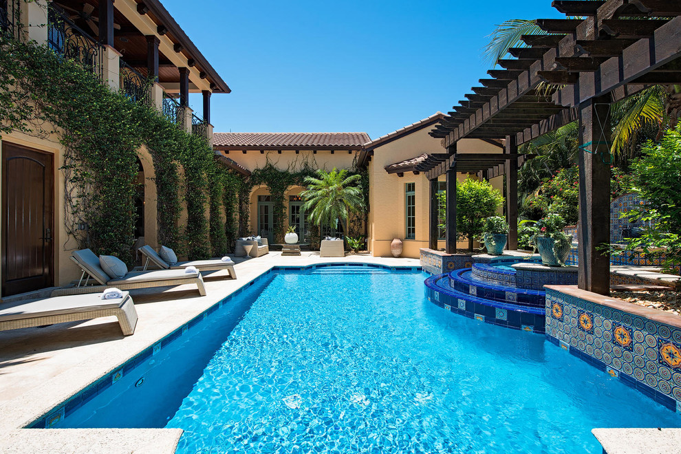 Mediterranean backyard custom-shaped pool in Miami.