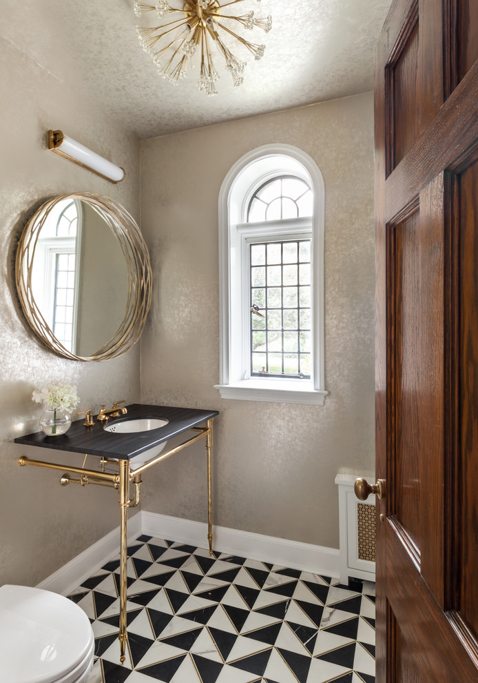 Inspiration for a traditional powder room in New York with beige walls, an undermount sink, multi-coloured floor and black benchtops.