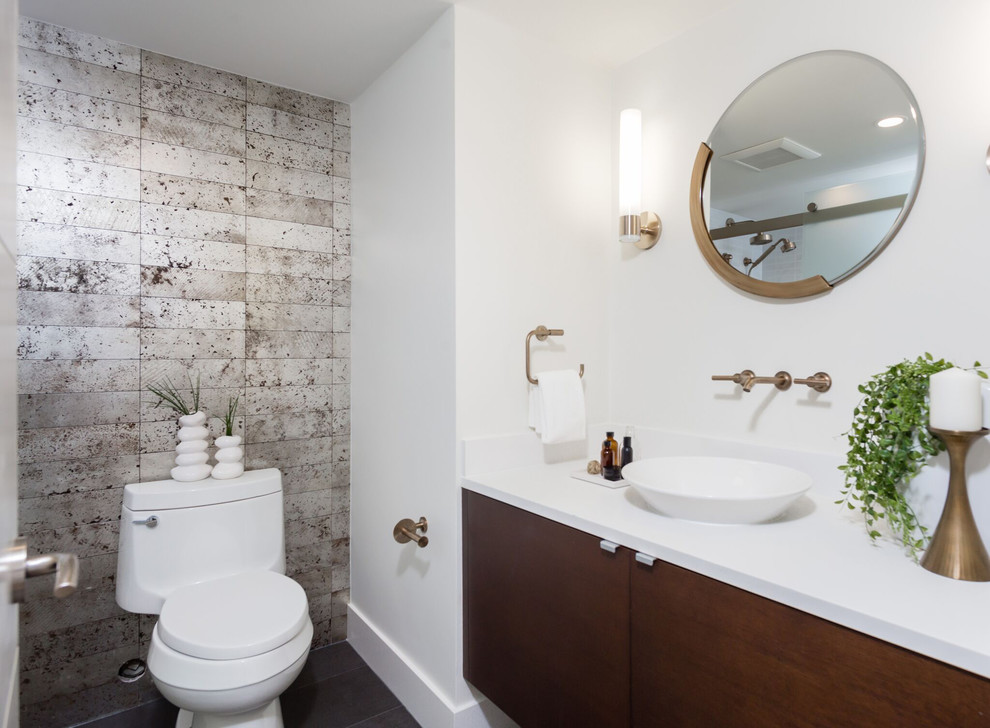Photo of a mid-sized transitional master bathroom in Vancouver with flat-panel cabinets, brown cabinets, an alcove tub, a shower/bathtub combo, a two-piece toilet, a vessel sink, solid surface benchtops, black floor and a sliding shower screen.