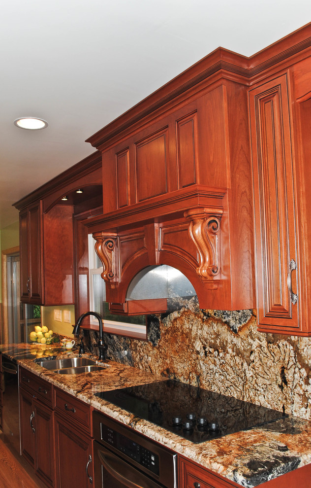 Eat-in kitchen - large u-shaped medium tone wood floor eat-in kitchen idea with raised-panel cabinets, medium tone wood cabinets, granite countertops, brown backsplash, stone slab backsplash, black appliances and an island