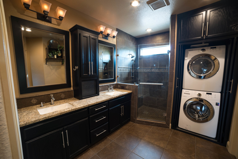 Mid-sized contemporary master bathroom in Sacramento with shaker cabinets, black cabinets, a corner shower, a two-piece toilet, porcelain tile, porcelain floors, a vessel sink, granite benchtops and a laundry.