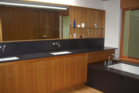 Photo of a large contemporary master bathroom in Seattle with flat-panel cabinets, medium wood cabinets and solid surface benchtops.