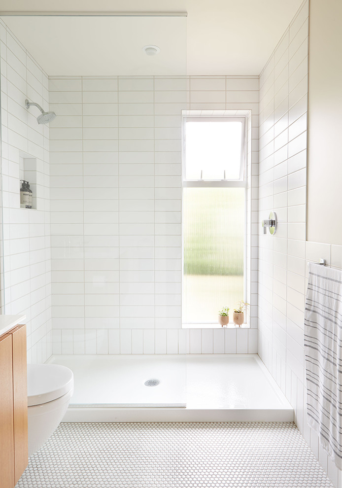 Inspiration for a small midcentury master bathroom in Seattle with flat-panel cabinets, medium wood cabinets, an alcove shower, a wall-mount toilet, white tile, ceramic tile, white walls, ceramic floors, an integrated sink, engineered quartz benchtops, blue floor and an open shower.