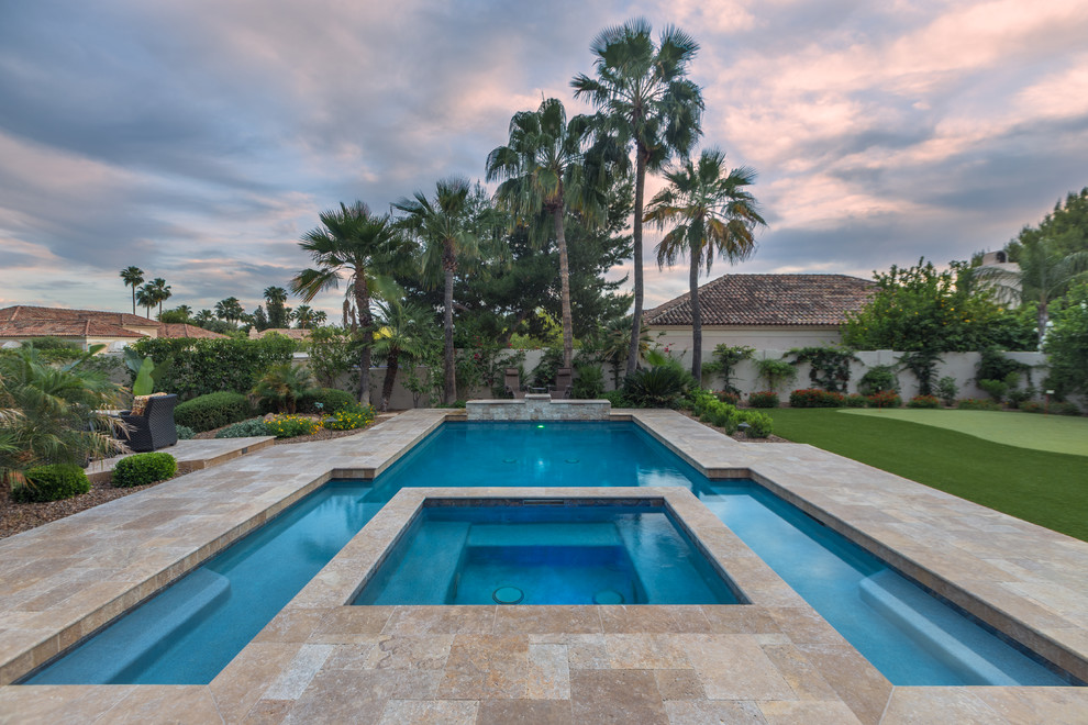 Large mediterranean backyard custom-shaped pool in Phoenix with a hot tub and tile.