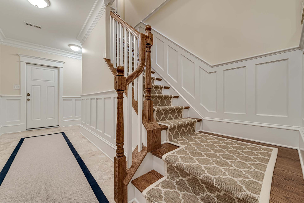 Inspiration for a wood l-shaped staircase in Philadelphia with painted wood risers, wood railing and decorative wall panelling.
