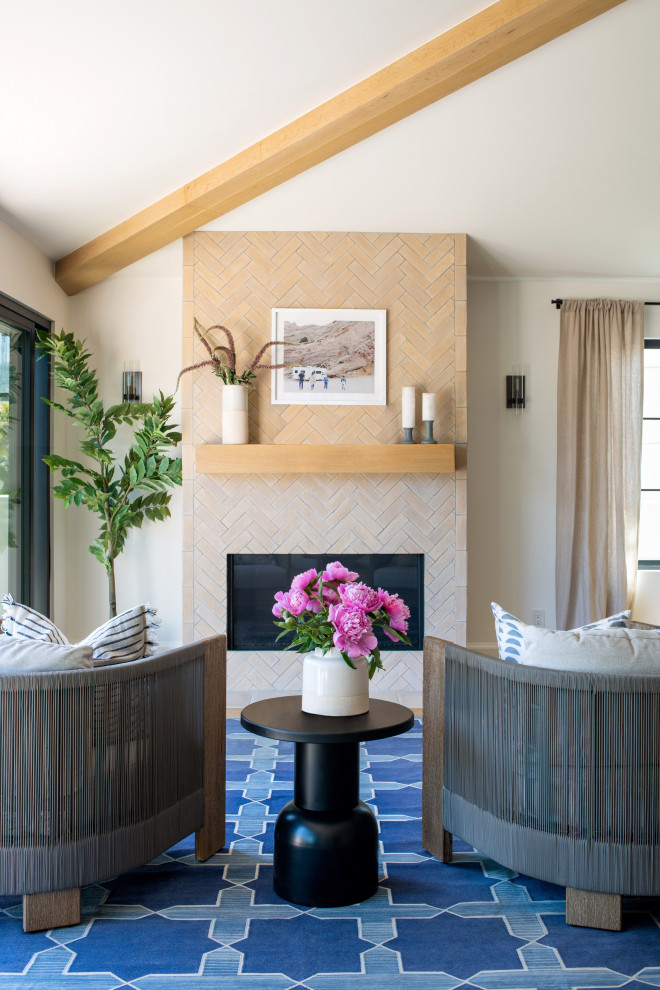 ロサンゼルスにある広い地中海スタイルのおしゃれな主寝室 (白い壁、淡色無垢フローリング、標準型暖炉、タイルの暖炉まわり、ベージュの床、表し梁) のインテリア
