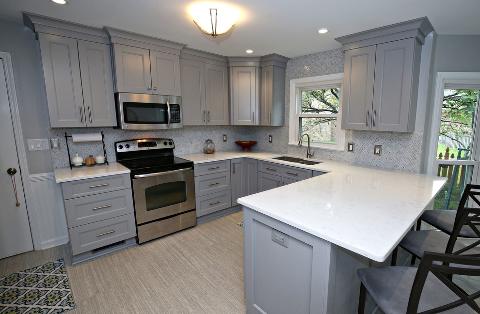 This is an example of a mid-sized traditional l-shaped eat-in kitchen in Louisville with shaker cabinets, grey cabinets, granite benchtops, stainless steel appliances and a peninsula.