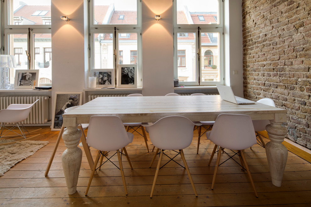 Industrial dining room in Cologne with medium hardwood floors.